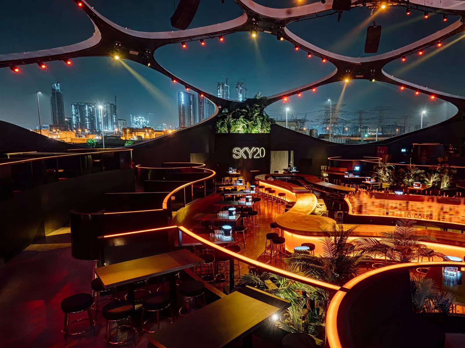 The SKY2.0 terrace at night with its glowing curved bars